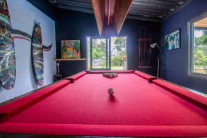 埃斯特角城Mundaka Hostel y Bar的室内一张台球桌,里面装有红色的斯诺克球