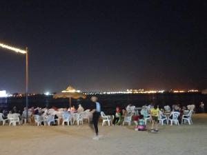 伊斯梅利亚قرية النورس مكتب السعد的一群人晚上坐在海滩上