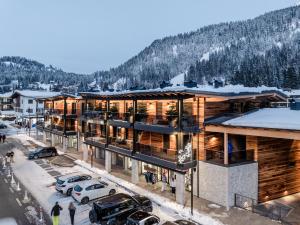 摩德纳迪-坎皮格里奥Campiglio WOOD的享有滑雪胜地的空中景色,停车场内有车辆停放