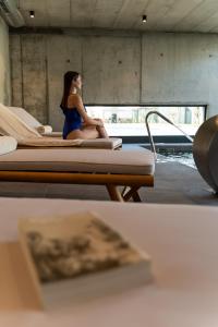 维拉·雷阿尔Borralha Hotel, Restaurante & Spa的坐在房间里床边的女人