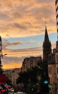 巴黎Chez les artistes de Ménilmontant的享有日落时教堂陡峭壁的城市美景