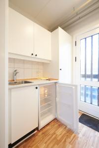 岑讷汽车公寓旅馆的厨房配有白色橱柜、水槽和窗户。