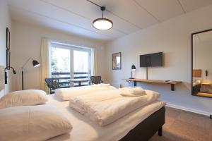 岑讷汽车公寓旅馆的客房设有三张床、一张桌子和电视。