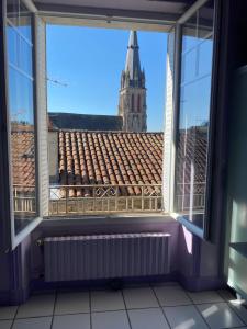 欧里亚克Les chambres de Marielou的享有教堂景致的开放式窗户