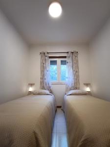 奥德米拉Apartamento KumiKata的带窗户的客房内的两张床