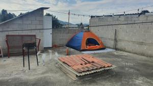 韦韦特南戈LA OFFI GT的蓝色和橙色的帐篷,位于砖墙旁边