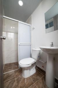 圣玛尔塔Hotel Santa Marta Tropical的白色的浴室设有卫生间和水槽。
