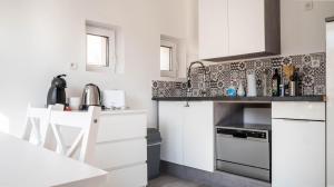 普瓦捷Le Modernisme - Joli T3 lumineux pour 4 pers的小厨房配有白色橱柜和炉灶。