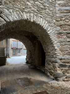 FrassinettoLa Cürt Brandon的石头建筑中的石拱门,设有入口