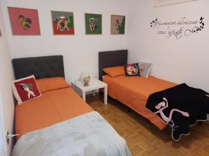罗韦雷托Appartamento Gisella的一张小房间内的两张床,墙上挂着照片