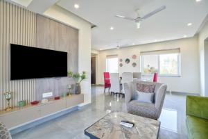 坎多林Premium 2BHK Apartment with pool at Candolim Beach的客厅设有壁挂式平面电视。