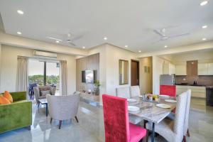 坎多林Premium 2BHK Apartment with pool at Candolim Beach的用餐室以及带桌椅的起居室。
