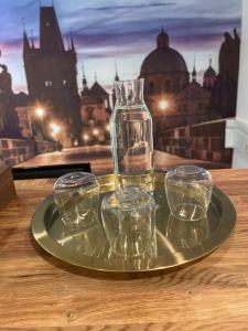 布拉格Hotel Oáza Praha的桌上装有四杯空玻璃杯的玻璃盘
