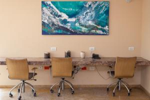 卡塔赫纳HOTEL OCEANIA的一张桌子、两把椅子和墙上的一幅画