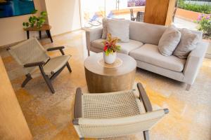 卡塔赫纳HOTEL OCEANIA的客厅配有沙发、椅子和桌子