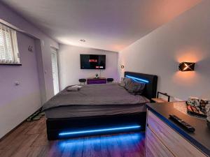 森克Green Oasis Garden的一间卧室配有一张带蓝色LED灯的床