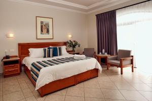 梅利哈Paradise Bay Resort的配有一张床和一把椅子的酒店客房