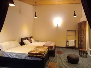 努沃勒埃利耶Aquaa Leaf Residences的一间卧室配有两张床、一个架子和灯