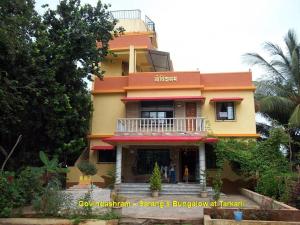 BhogweGovindaashram的黄色和橙色的建筑,设有阳台