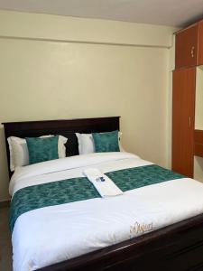 KerichoThe comfortplace oak 102的一间卧室配有一张带绿色和白色床单的大床