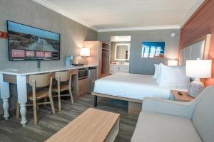 比奇港Spray Beach Hotel的配有一张床和一张书桌的酒店客房