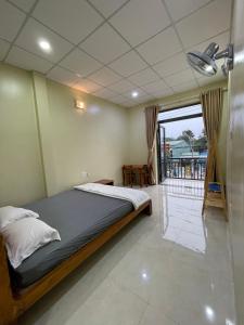 河仙Nhà nghỉ Hoa Dũng的一间卧室设有一张床和一个阳台