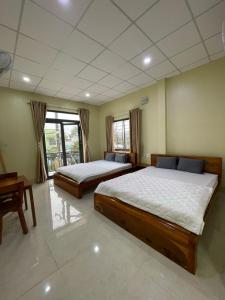 河仙Nhà nghỉ Hoa Dũng的一间卧室配有两张床和一张桌子