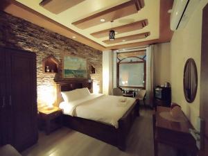 尼兹瓦Durrat Nizwa Hotel的一间卧室设有一张大床和砖墙