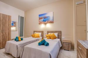 梅利哈Aloha - Village Apartment 2 BR in Mellieha的两张位于酒店客房的床,配有黄色和蓝色枕头