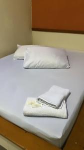 贝洛奥里藏特Hotel Angely的一张带两个枕头的白色床和毛巾