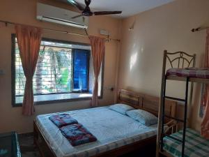 BhogweGovindaashram的一间卧室配有双层床和窗户。
