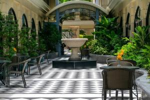 曼谷The Sukosol Hotel的一座带椅子的庭院和一座位于大楼内的喷泉