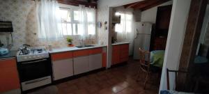 马德普拉塔Casa, quincho, garage y parque.apta 10 personas的厨房配有炉灶和冰箱。