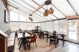 奇德尔曼彻斯特钱德尔乡村酒店的餐厅设有桌椅和大窗户。