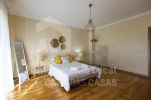 埃里塞拉Villa BelaVista by ACasaDasCasas的一间卧室配有带白色床单和黄色枕头的床。