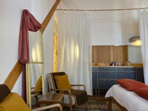 塔维拉卡萨贝莱扎多索旅馆的一间带床和厨房的客厅