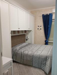 丽都迪奥斯蒂亚Appartamento 50 mt dal mare的一间卧室配有一张床和白色橱柜