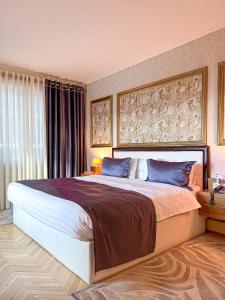 地拉那地拉那国际酒店及会议中心的一间卧室配有一张带蓝色枕头的大床