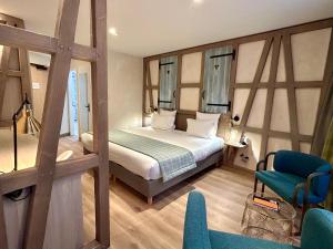 斯特拉斯堡宝库尔酒店的一间卧室,卧室内配有一张床和一把椅子
