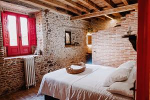 Castillo de BayuelaLa Casita De Albino的卧室设有红色的门和砖墙