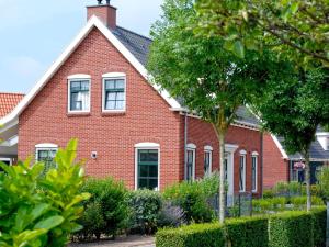 科莱恩斯普拉特Vintage Holiday Home in Colijnsplaat near Forest的红砖房子,有树和灌木