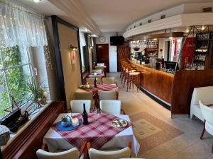 乌赫尔堡Wellness Hotel Staré Město的一间带桌椅的餐厅和一间酒吧