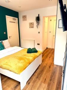 珀利Beautiful Studio flat的卧室配有白色床和黄色毯子