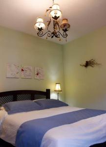 埃拉蒂特里卡隆ΛΑΓΟΥΜΙ suite Α3的一间卧室配有蓝色的床和吊灯。