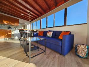 特尔德St George's Apartments - Gran Canaria的客厅配有蓝色的沙发和桌子