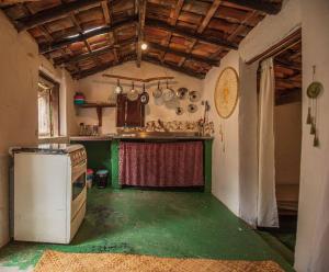 韦尔卡鲍Casinha privativa sem suíte.的一间带炉灶的厨房,铺有绿色地板。