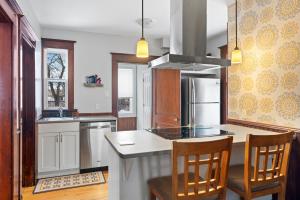 蒙克顿Beautiful Victorian Home Located Downtown Moncton的厨房配有带椅子的柜台和冰箱。