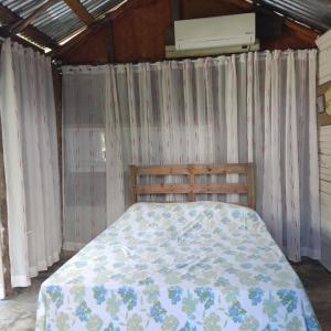 HigueyLa Loma Camping的一间卧室配有带窗帘的床和空调