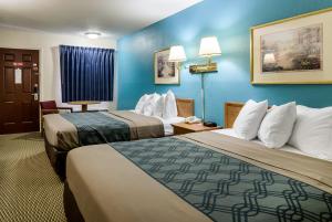 苏城苏城品质酒店和套房的两张位于酒店客房的床,拥有蓝色的墙壁