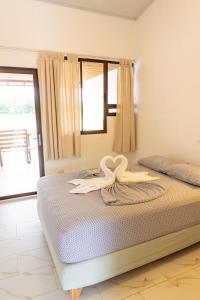 托尔图格罗Hotel Pura Natura Riverside Tortuguero的一间卧室配有一张带两个天鹅的床